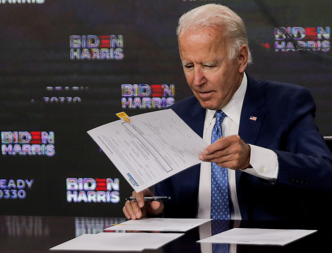 FILE PHOTO: Democratic presidential candidate Joe Biden signs official documents needed to receive his party's official nomination next week during an event in Wilmington, Delaware, U.S., August 14, 2020. REUTERS/Carlos Barria
