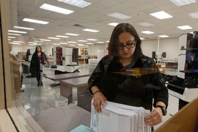 FOTO DE ARCHIVO: Eliza Luna, una diseñadora de papeletas en el Departamento de Elecciones del Condado de Maricopa, cuenta boletas para las Elecciones de Preferencias Presidenciales en un centro en Phoenix, Arizona, EEUU, 17 de marzo de 2020. REUTERS/Cheney Orr/Foto de archivo