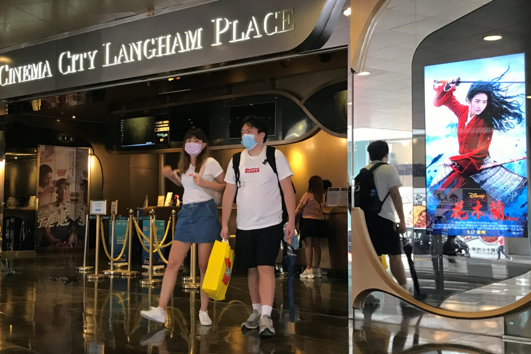 Personas caminan cerca de una publicidad del filme Mulan de Disney en un cine en Hong Kong, China, 8 de septiembre del 2020. REUTERS/Aleksander Solum
