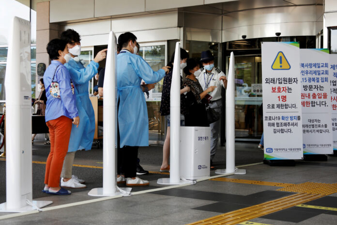 FOTO DE ARCHIVO: Un grupo de personas con los rostros protegidos por máscaras hacen cola para acceder al interior de un hospital en Seúl, Corea del Sur, el 26 de agosto de 2020. REUTERS/Kim Hong-Ji