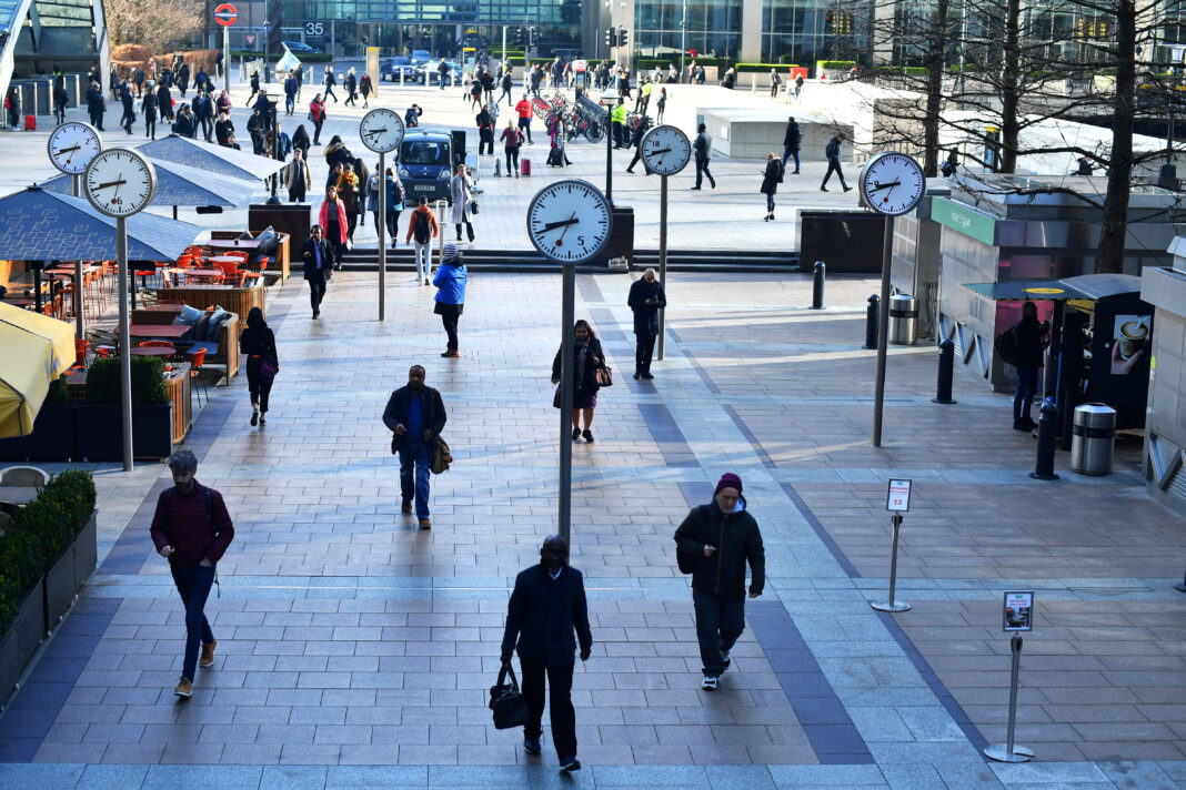 FILE PHOTO: Commuters walk through Canary Wharf, as the number of coronavirus cases grow around the world, in London, Britain March 16, 2020. REUTERS/Dylan Martinez