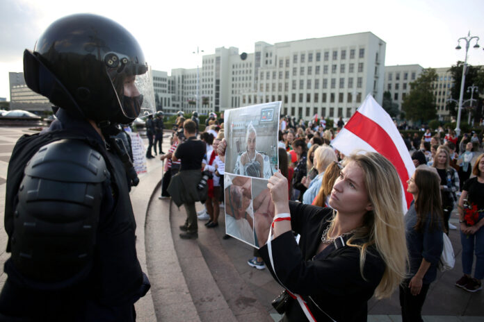 FOTO DE ARCHIVO: Una mujer sostiene un póster con fotos de personas heridas frente a un oficial de la ley durante una manifestación contra la brutalidad policial tras las protestas para rechazar los resultados de las elecciones presidenciales en Minsk, Bielorrusia. 5 de septiembre de 2020. Tut.By/Handout via REUTERS. ATENCIÓN EDITORES - ESTA IMAGEN HA SIDO ENTREGADA POR UN TERCERO. NO DISPONIBLE PARA REVENTA NI ARCHIVO. CREDITO OBLIGATORIO