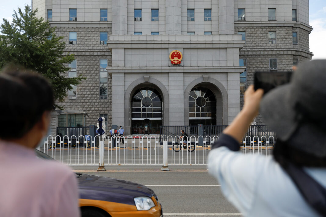 FOTO DE ARCHIVO: Una mujer sostiene un teléfono móvil frente al Tribunal Popular Intermedio Nº 2 de Pekín, China, el 11 de septiembre de 2020. REUTERS/Carlos Garcia Rawlins