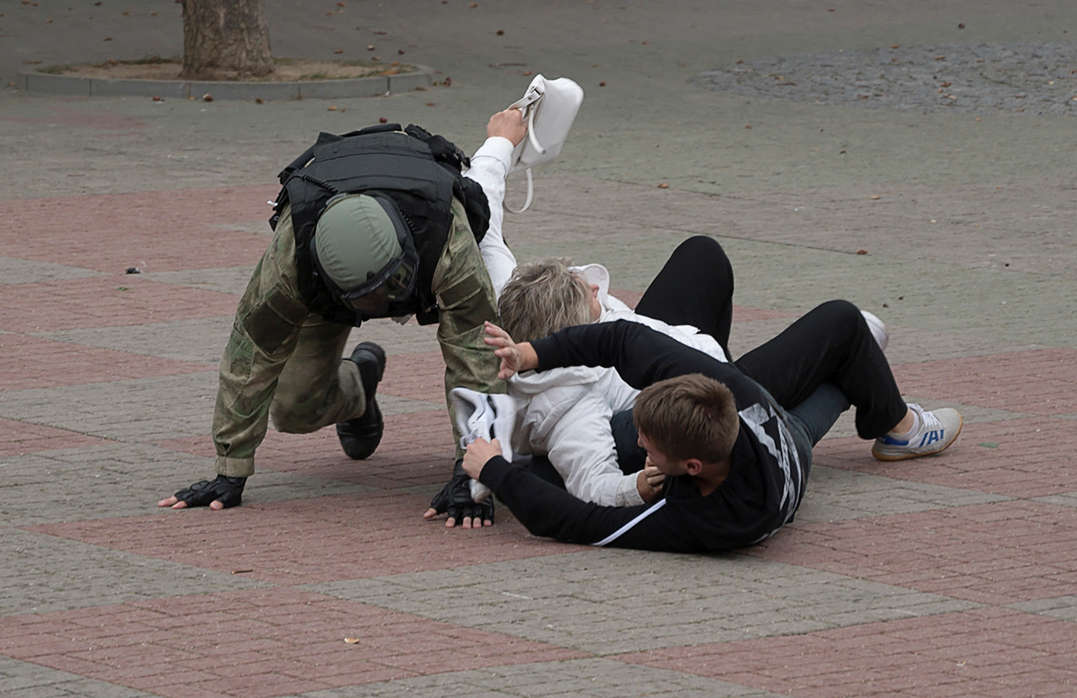 Un agente del orden público de Belarús intenta detener a un hombre y una mujer en Grodno, Belarús, el 27 de septiembre de 2020. BelaPAN vía REUTERS