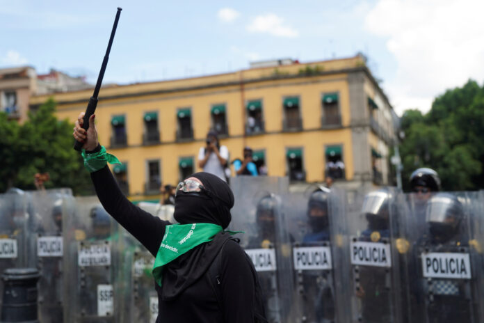 Una integrante de un colectivo feminista hace gestos cuando se enfrenta a agentes de policía durante una marcha para conmemorar el Día Internacional del Aborto Seguro en la Ciudad de México, México 28 ​​de septiembre de 2020