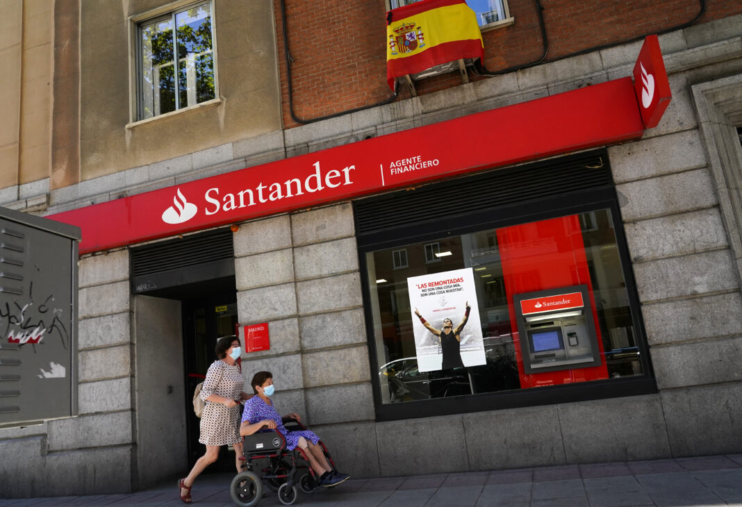 FOTO DE ARCHIVO. Mujeres con mascarillas caminan frente a una sucursal de Banco Santander, en Madrid, España. 2 de julio de 2020. REUTERS/Juan Medina