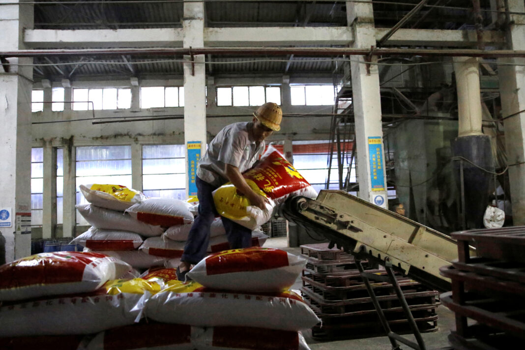 FOTO DE ARCHIVO. Un empleado mueve un saco de alimento para cerdos dentro de una planta de New Hope Liuhe, en Xichang, China. 11 de septiembre de 2020. REUTERS/Tingshu Wang