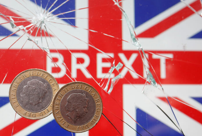 IMAGEN ILUSTRATIVA: Monedas de libra sobre un cristal fragmentado tras el que se ve la bandera de Reino Unido con la palabra 