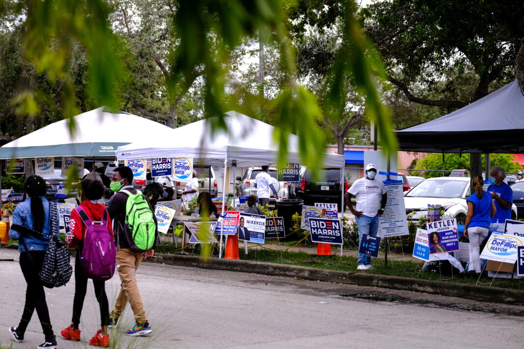 Gente hace campaña en la mesa de votación de la Biblioteca Pública de North Miami cuando comienza la votación anticipada antes de las elecciones en Miami, Florida, EEUU. 19 de octubre de 2020. REUTERS/Maria Alejandra Cardona