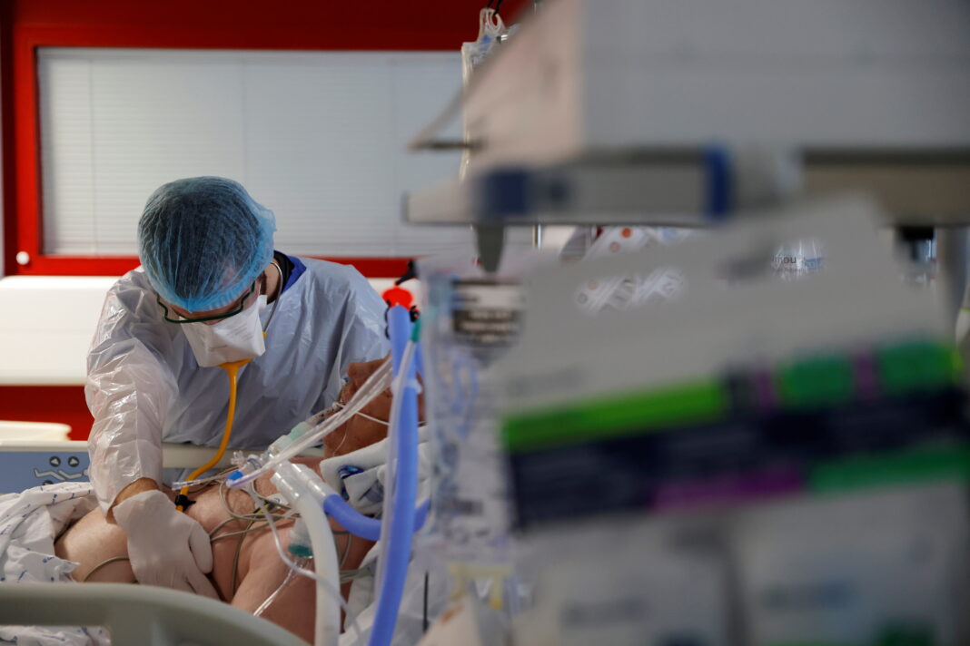 FOTO DE ARCHIVO: Un médico provisto con un equipo de protección individual (EPI) atiende a un paciente en la unidad de cuidados intensivos del hospital Bethune-Beuvry de Beuvry, Francia, el 16 de octubre de 2020. REUTERS/Pascal Rossignol