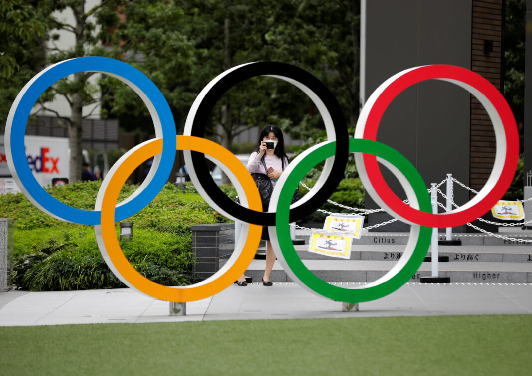 IMAGEN DE ARCHIVO. Una mujer utilizando mascarilla toma una fotografía a os anillos olímpicos frente al Estadio Nacional de Tokio, Japón October 14, 2020. REUTERS/Kim Kyung-Hoon
