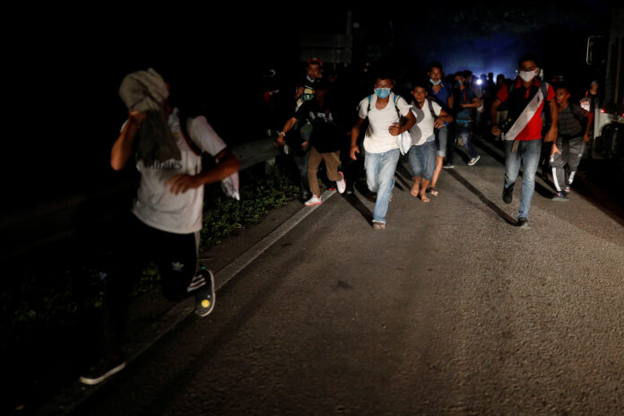 Migrantes hondureños que buscan llegar a EEUU, huyen tras arrojar piedras a soldados guatemaltecos que bloqueaban una carretera para evitar que siguieran a la frontera con México, en San Pedro Cadenas, Guatemala. 2 de octubre de 2020. REUTERS/Luis Echeverria