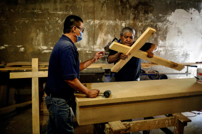 Empleados de la Funeraria Ríos hacen cruces de madera en un taller para ser utilizadas en entierros, mientras continúa la pandemia del coronavirus en Ciudad Juárez, México. 7 de octubre de 2020. REUTERS/Jose Luis Gonzalez