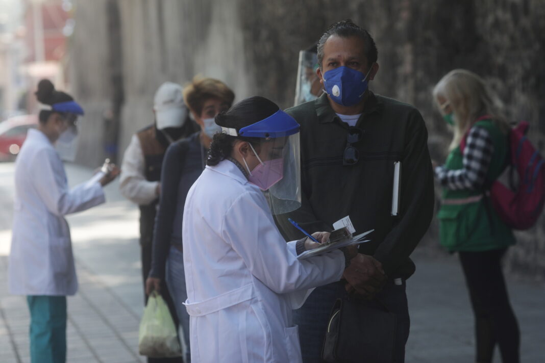 Los trabajadores de la salud que usan equipo de protección personal (EPP) dan instrucciones a las personas antes de administrar muestras de hisopo para la prueba de la enfermedad del coronavirus (COVID-19) en el Parque Coyoacán en la Ciudad de México, México, 22 de octubre de 2020. REUTERS / Henry Romero/ Foto de archivo